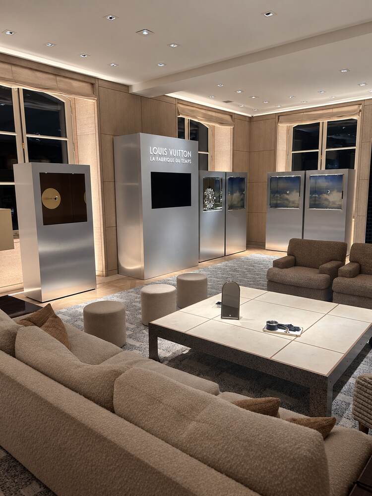 Salon d'exposition aux tons beiges, mobilier et totems