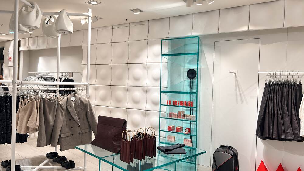 Boutique de prêt-à-porter blanche et présentoirs en verre