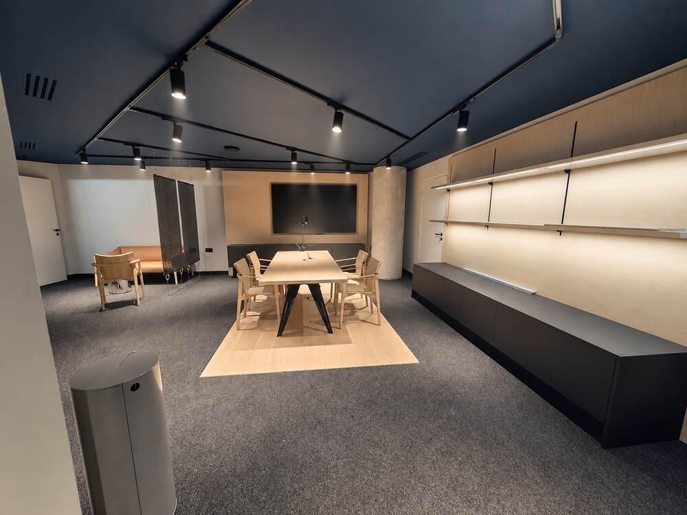 Salle de réunion au plafond sombre et grande table