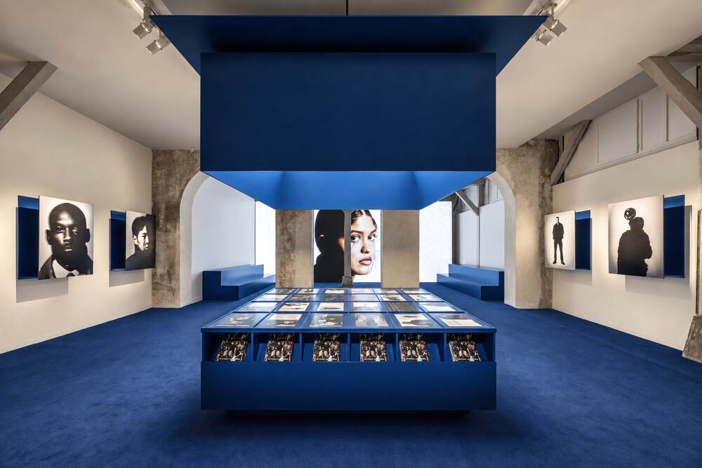 Exposition aux tons bleus, vitrine centrale et portraits