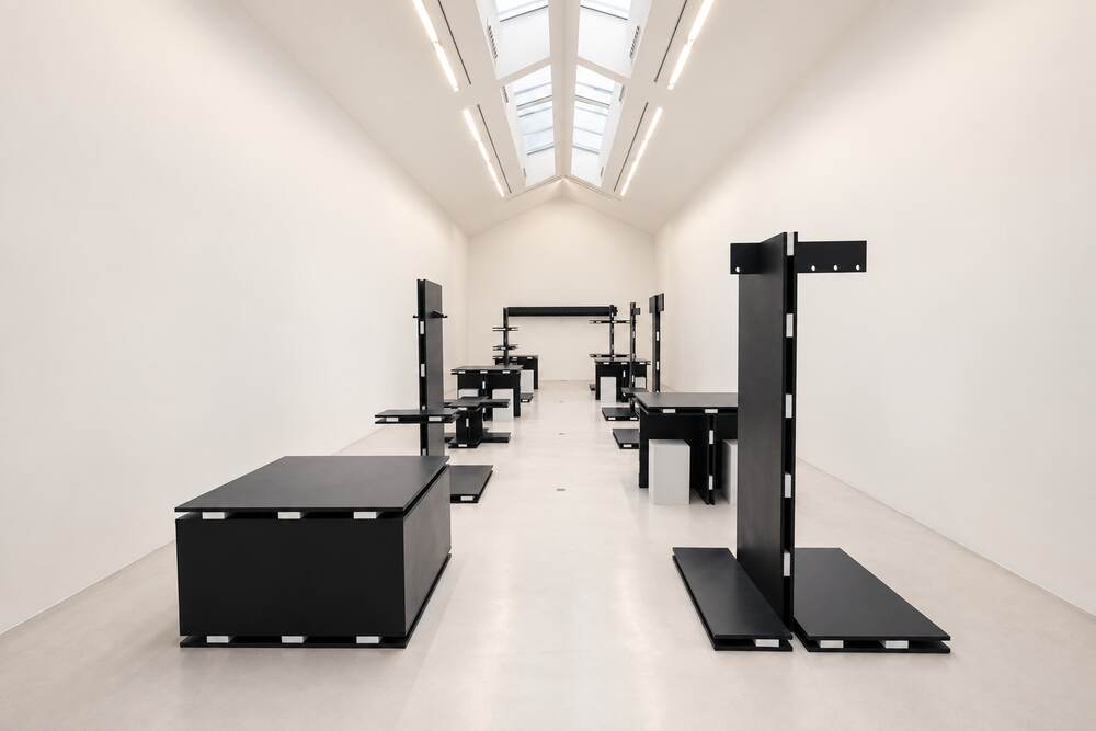 Scénographie noire minimaliste dans une galerie blanche