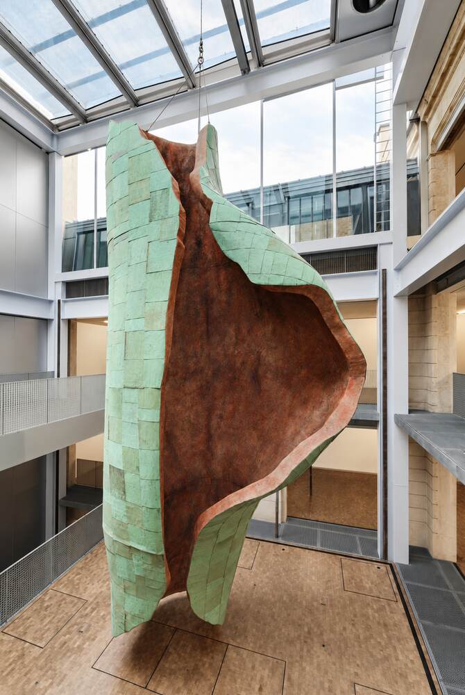 Sculpture monumentale verte et cuivrée dans un atrium